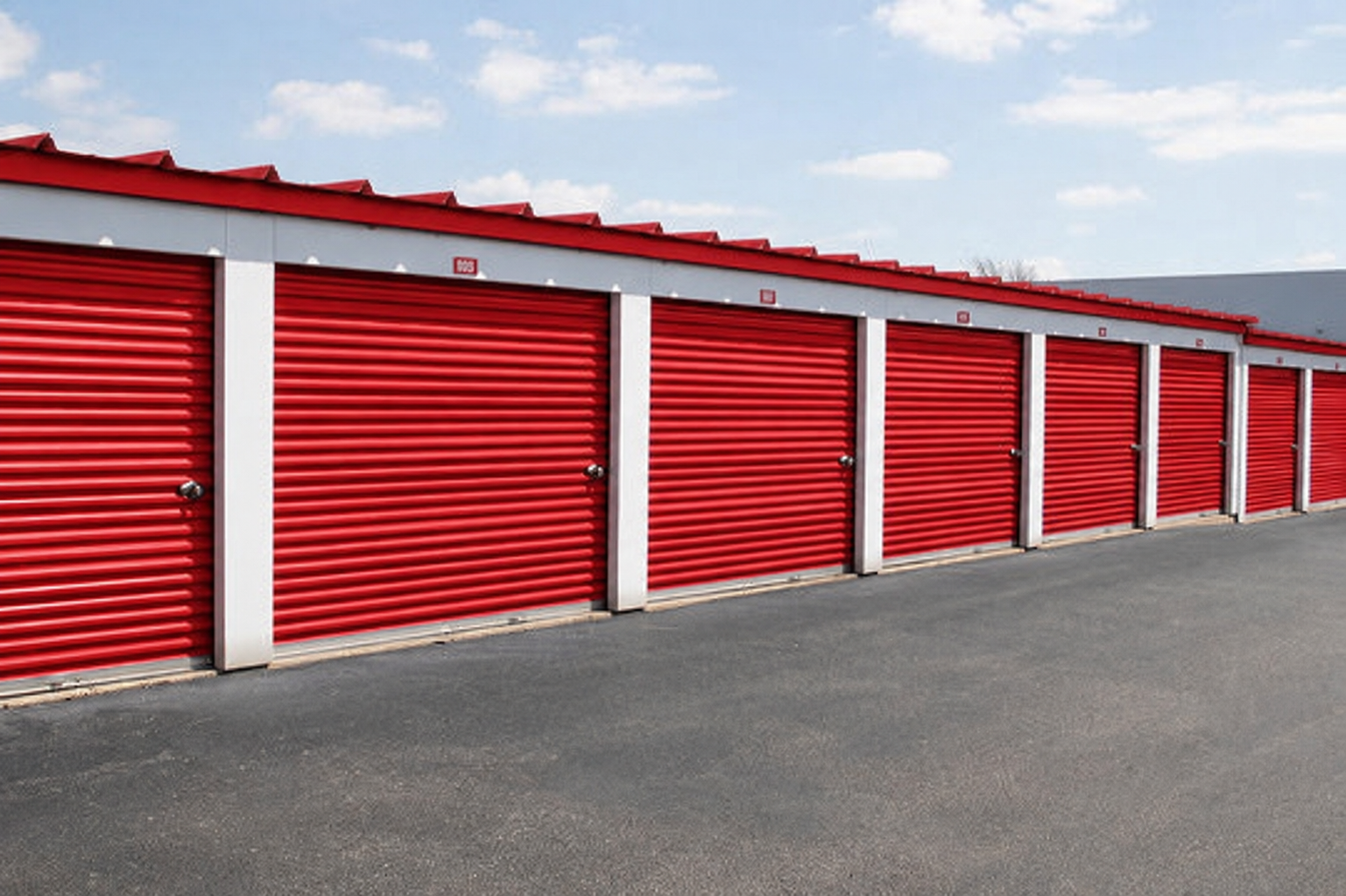 Row of Red D Stor storage units with bright red roll-up doors